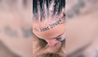 Tattooed prostitute with a nose ring blows her client