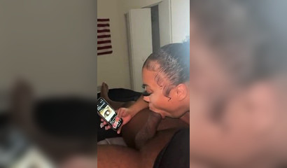 Ebony nympho watches porn on her phone while sucking a BBC