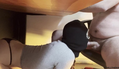 Masked slut deepthroats a fat dude's dick under the desk