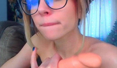 Nerdy blondie deepthroats a dildo and plays with her tits