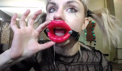 Nympho teen uses a mouth opener when deepthroating her dildo