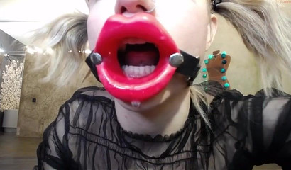 Nympho teen uses a mouth opener when deepthroating her dildo