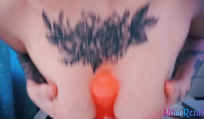 Inked babe wanks a dildo with her big tits & blows it