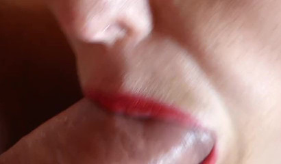 Close-up of CumAddictedLaia's red lips wrapped around a schlong