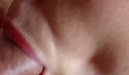 Close-up of CumAddictedLaia's red lips wrapped around a schlong